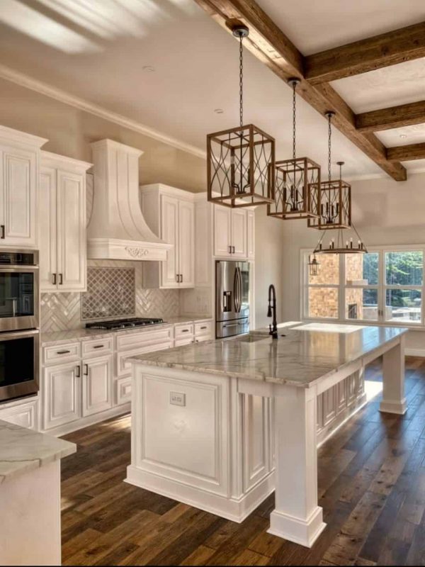 Elegant white kitchen with custom cabinetry, marble island, and rustic wooden ceiling beams, perfect for luxurious home design and remodel projects.