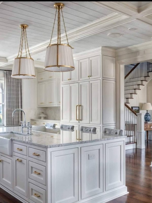 Aurea Kitchens white traditional kitchen with elegant cabinetry, marble countertops, and gold hardware, featuring a large central island, ample natural light, and classic design elements for a luxurious culinary space.
