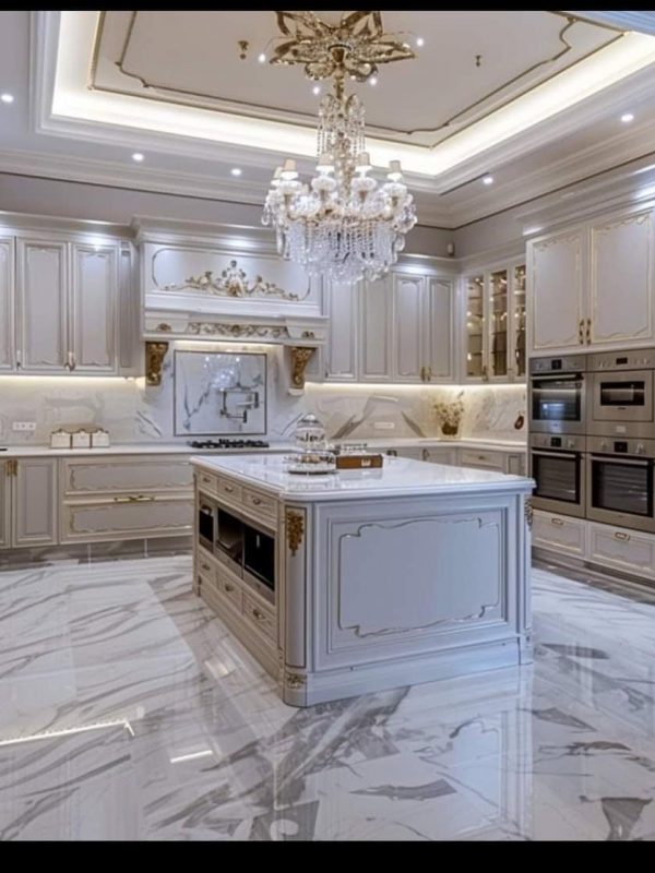 Luxury kitchen design with elegant white cabinetry and marble countertops, featuring built-in modern appliances and intricate chandeliers for a sophisticated cooking space.