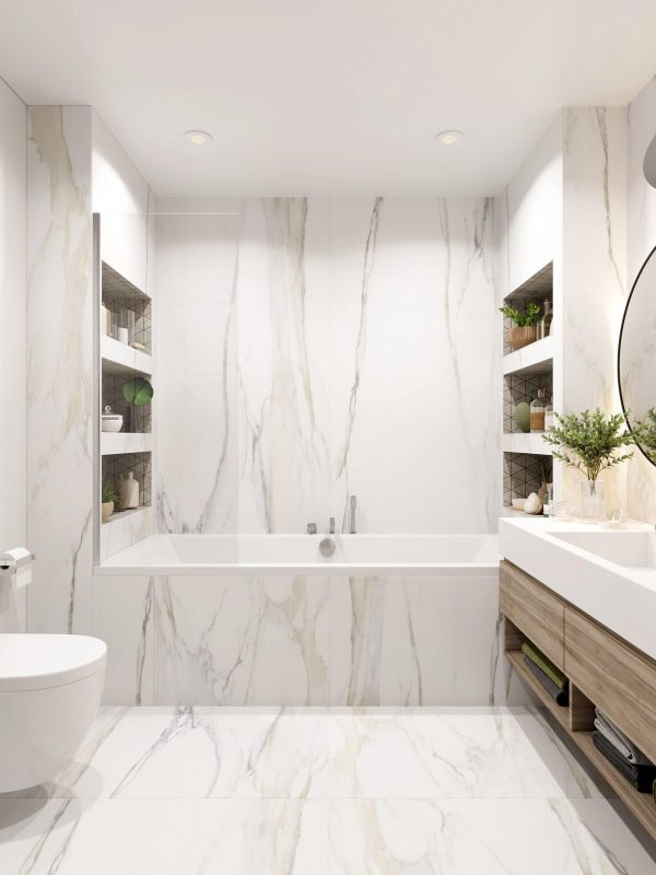 Luxurious modern bathroom with white marble walls and flooring, built-in shelves, sleek vanity, and contemporary fixtures, showcasing elegant bathroom design & renovation by Aurea Kitchens.